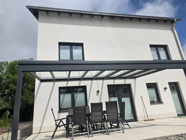 Terrassendach aus Alu mit Glas über der Terrasse eines Einfamilienhauses